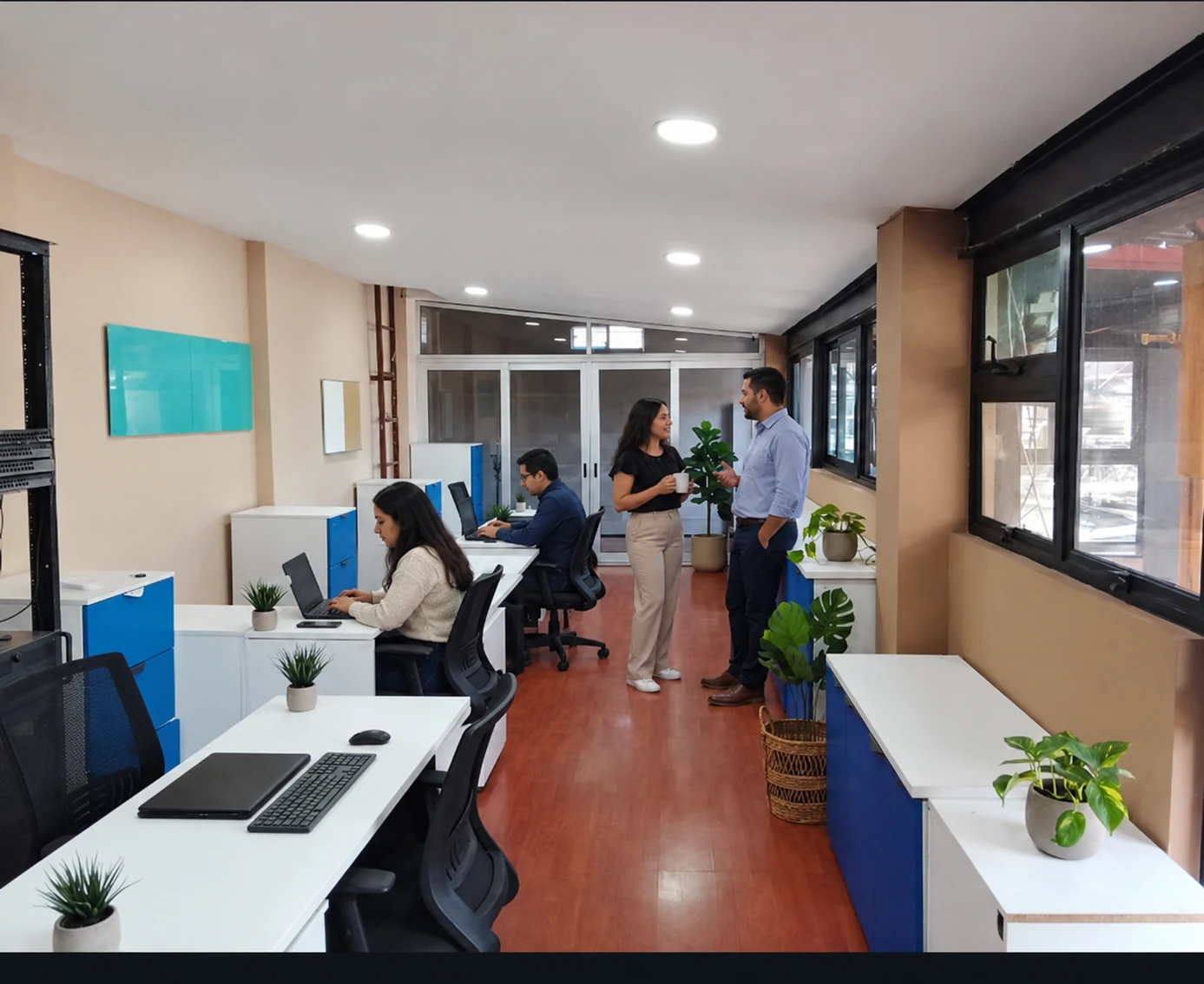 Área de oficina con cubículos y mesas de trabajo.